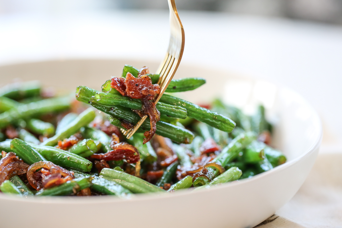 Caramelized green beans on a fork with bacon
