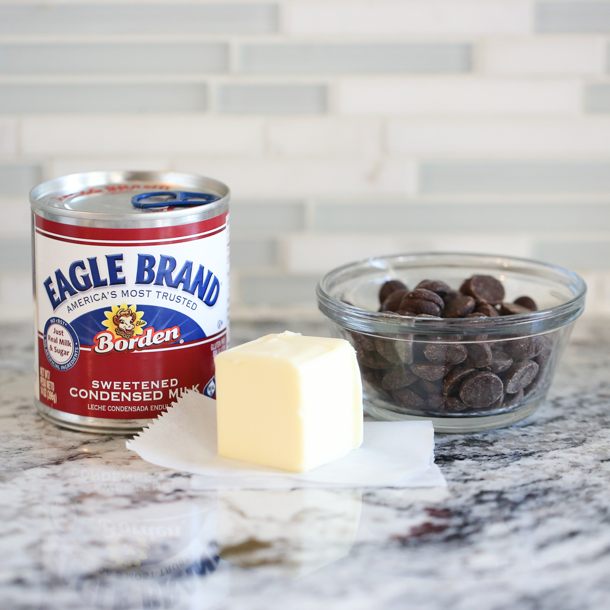 butter, sweetened condensed milk, and chocolate on a counter top