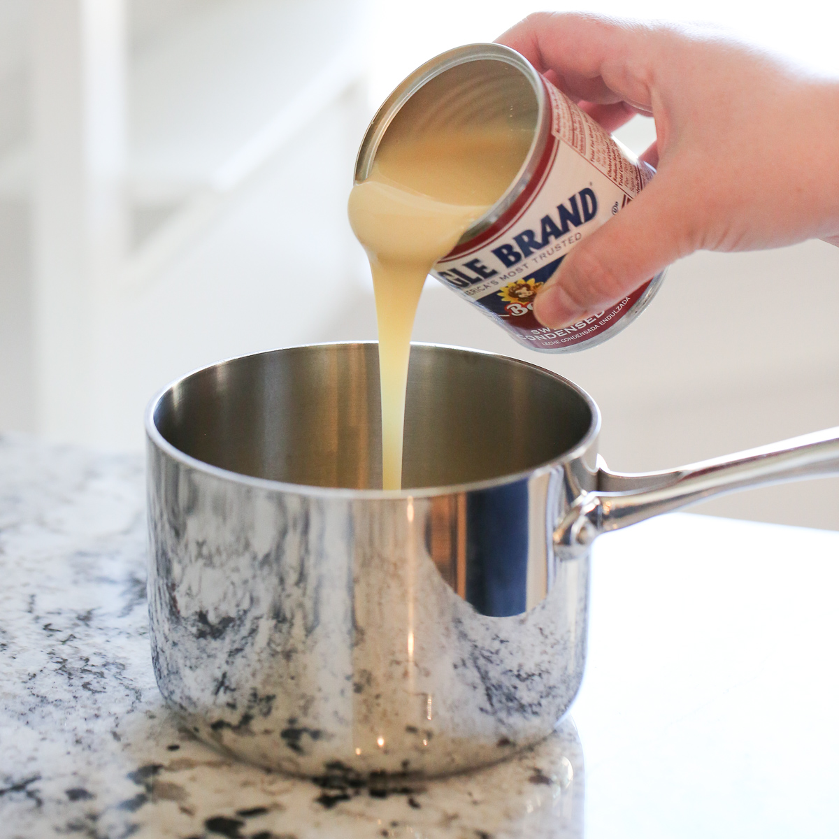 sweetened condensed milk pouring into a pan