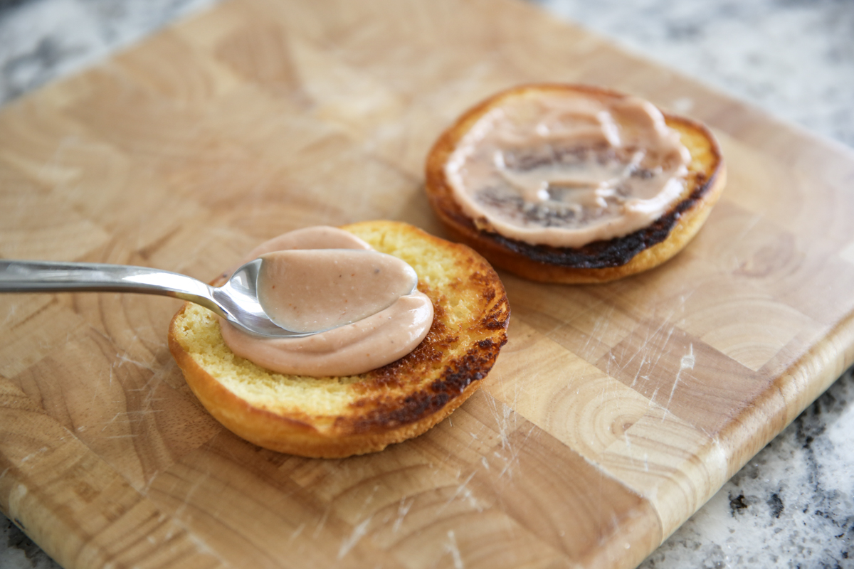 spreading sauce on buns