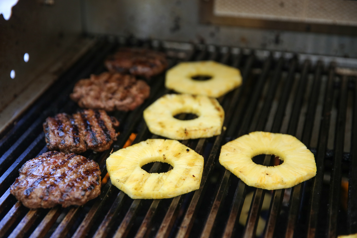 Pineapple and burgers on a grill
