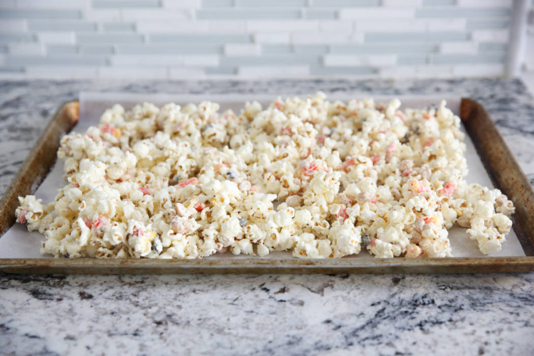 popcorn mix spread out on cookie sheet
