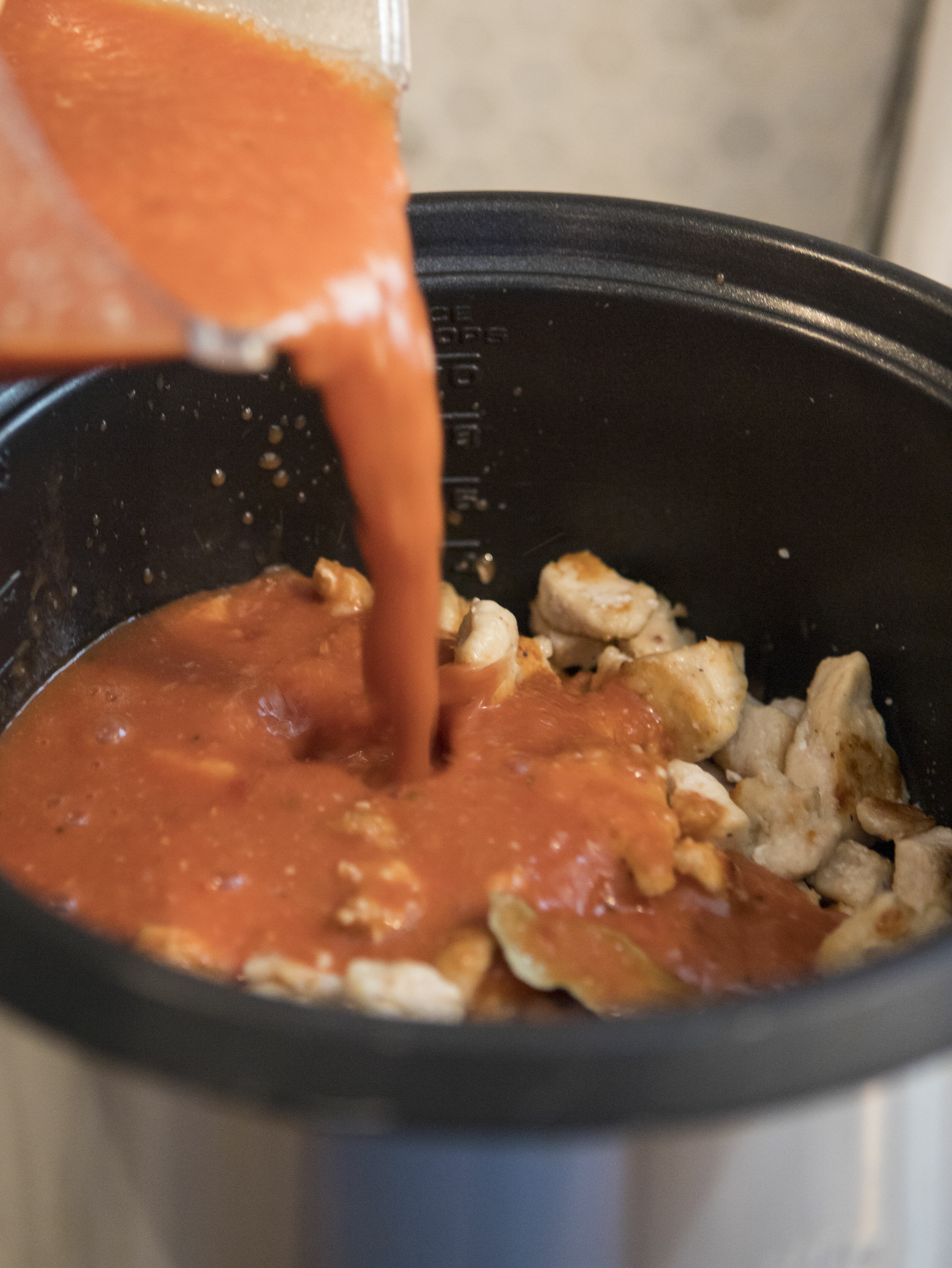 pouring sauce over chicken