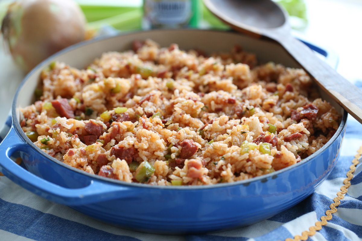 blue cast iron pan with jambalaya in it on a set table