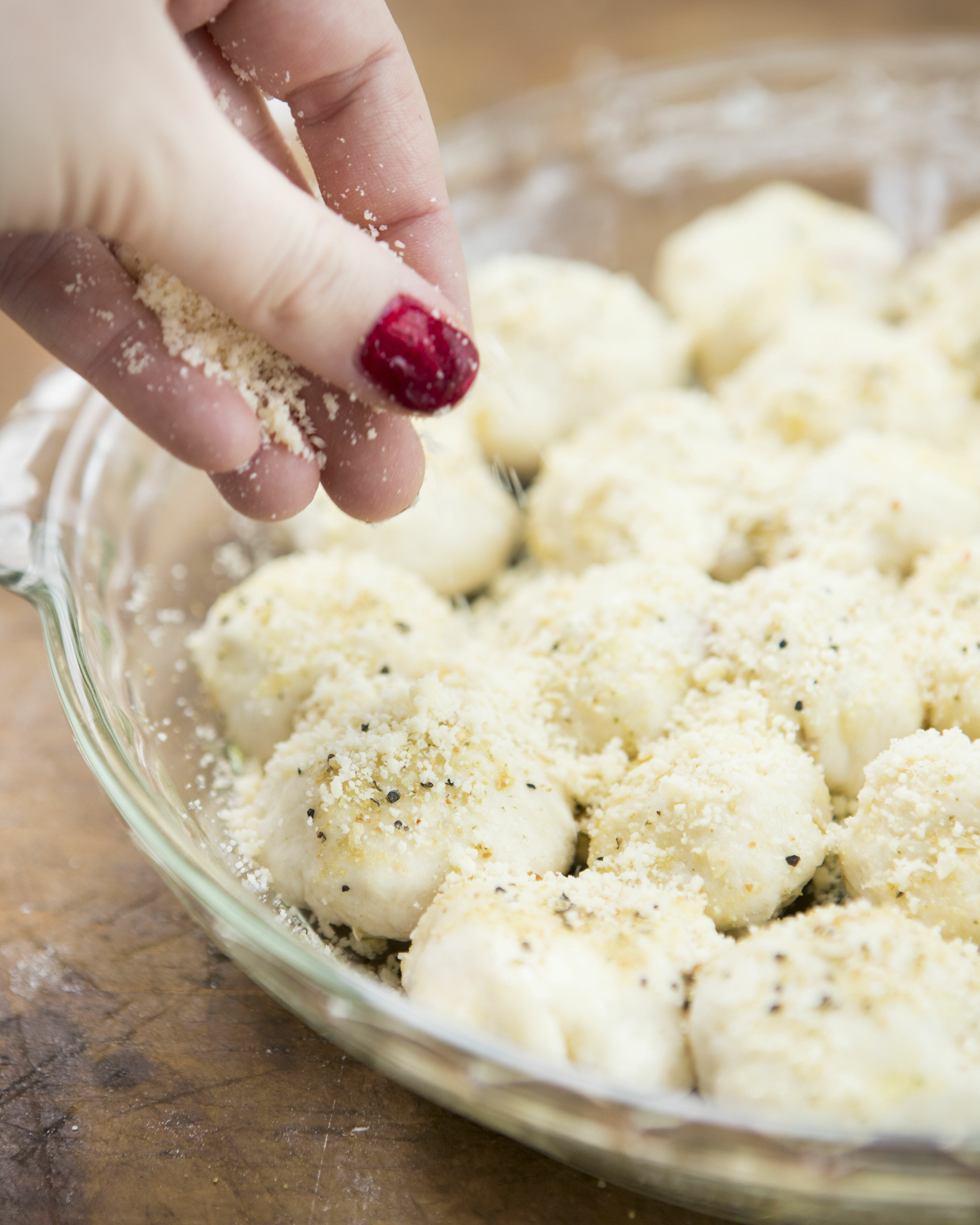 sprinkling pizza rolls with parmesan