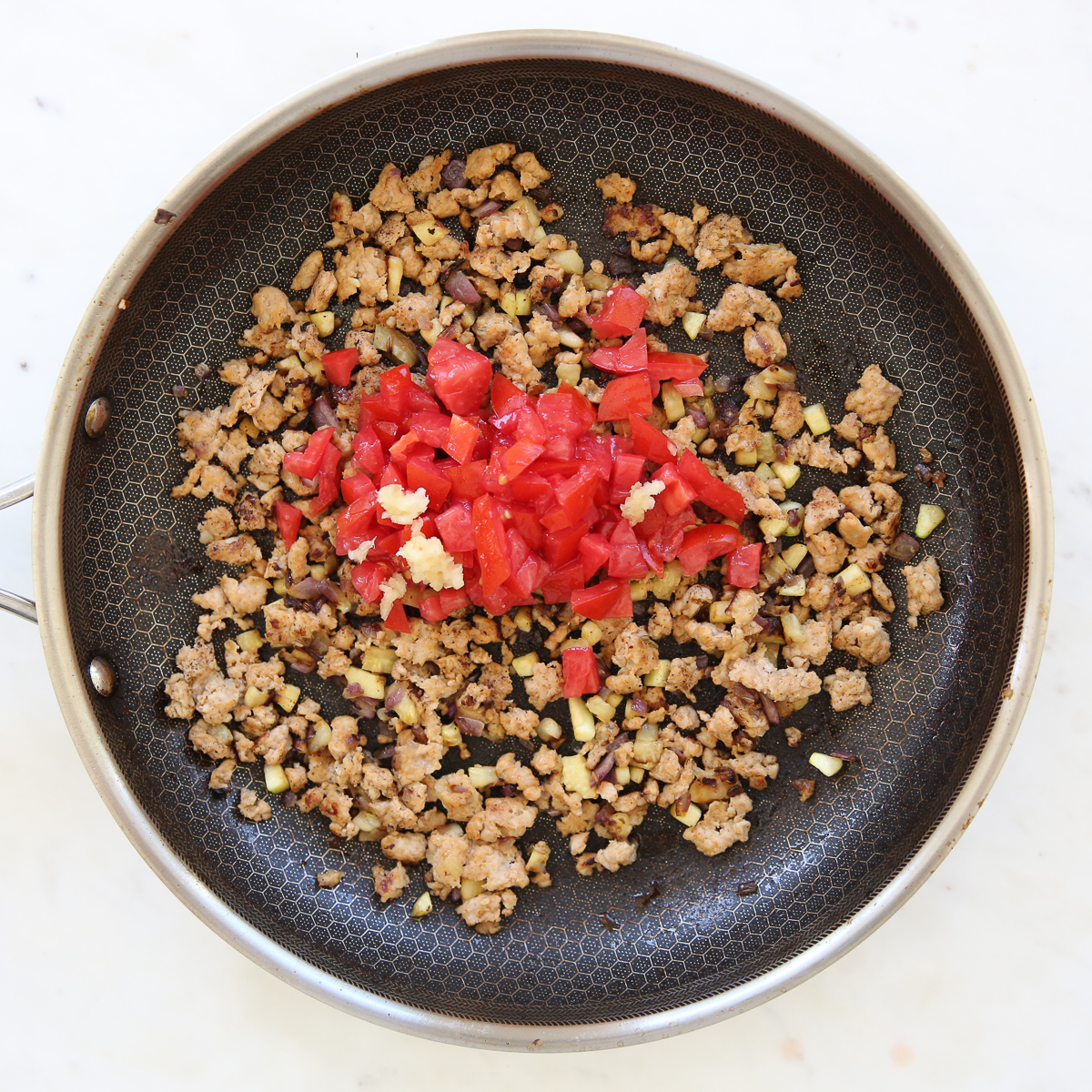 Cooked sausage and tomato in a skillet