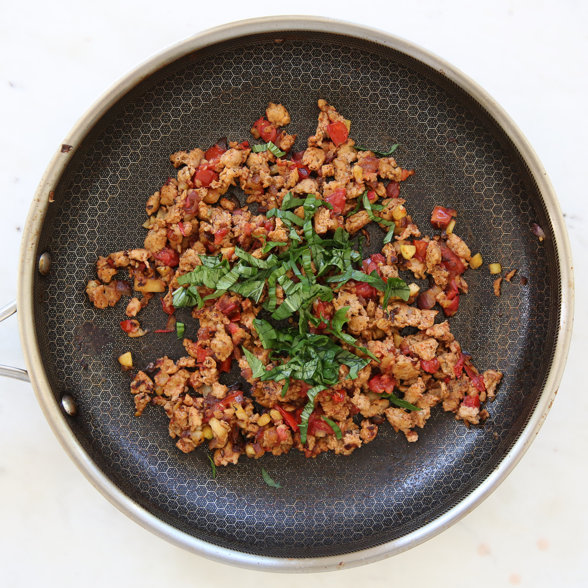 Cooked sausage and tomato in a skillet