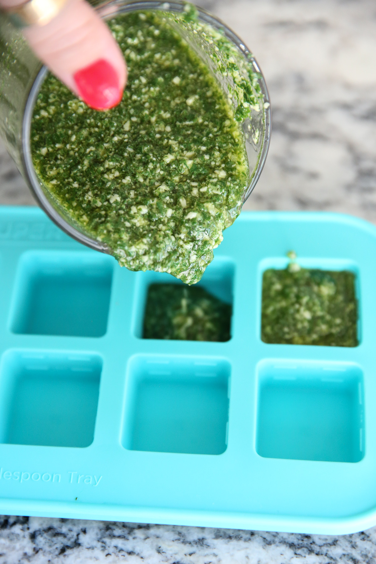 pouring pesto into freezer tray