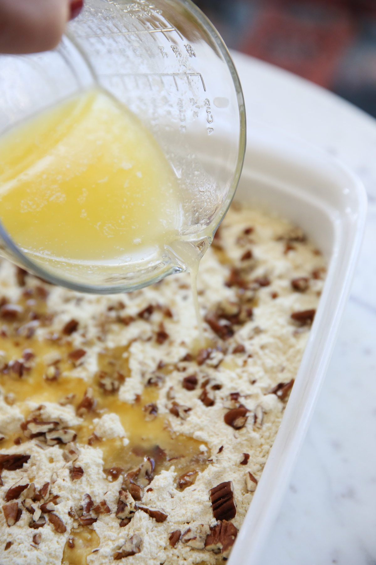 pouring melted butter on dump cake