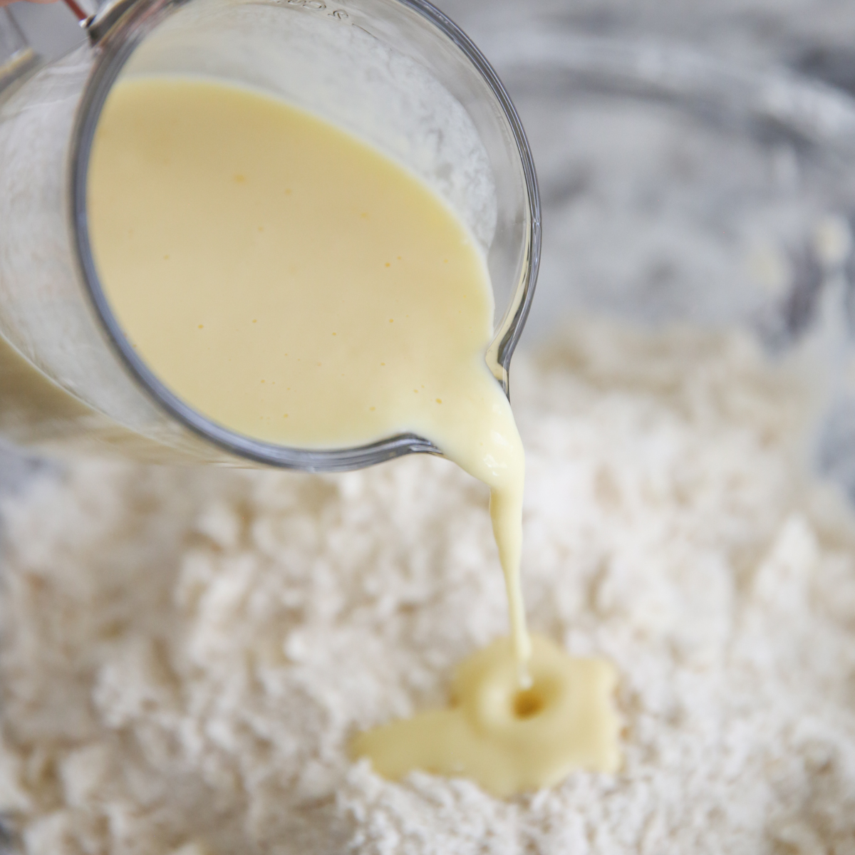 pouring wet ingredients into biscuit dough