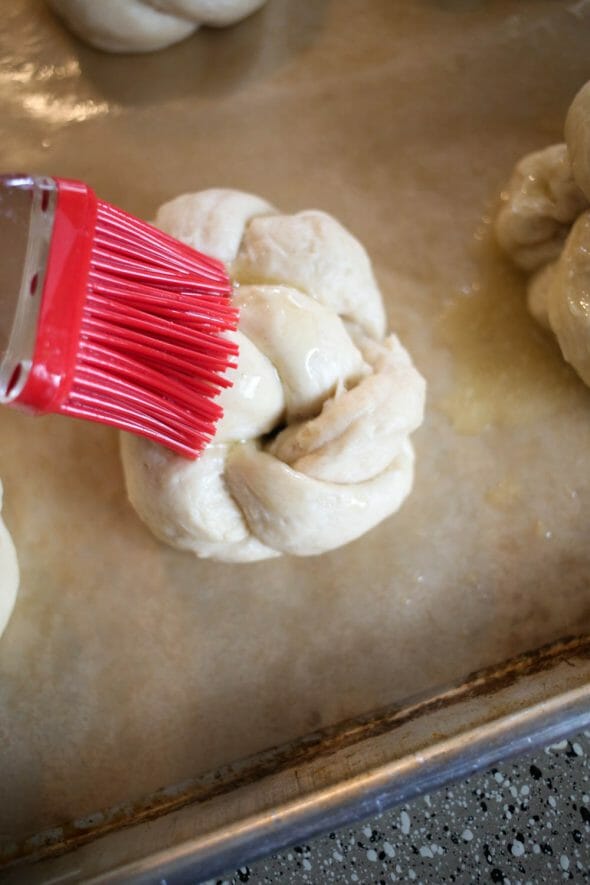 brushing butter on king cakes