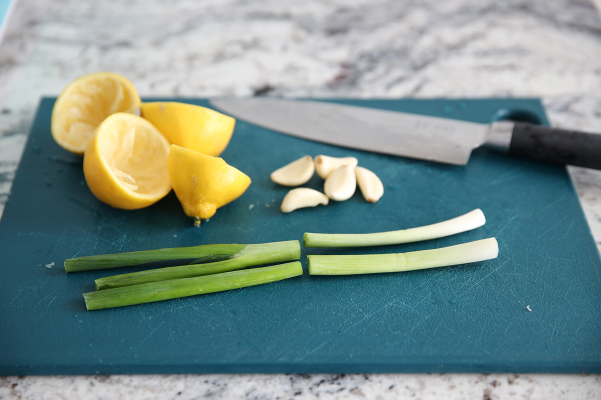 Lemons, garlic, and green onions on a cutting board