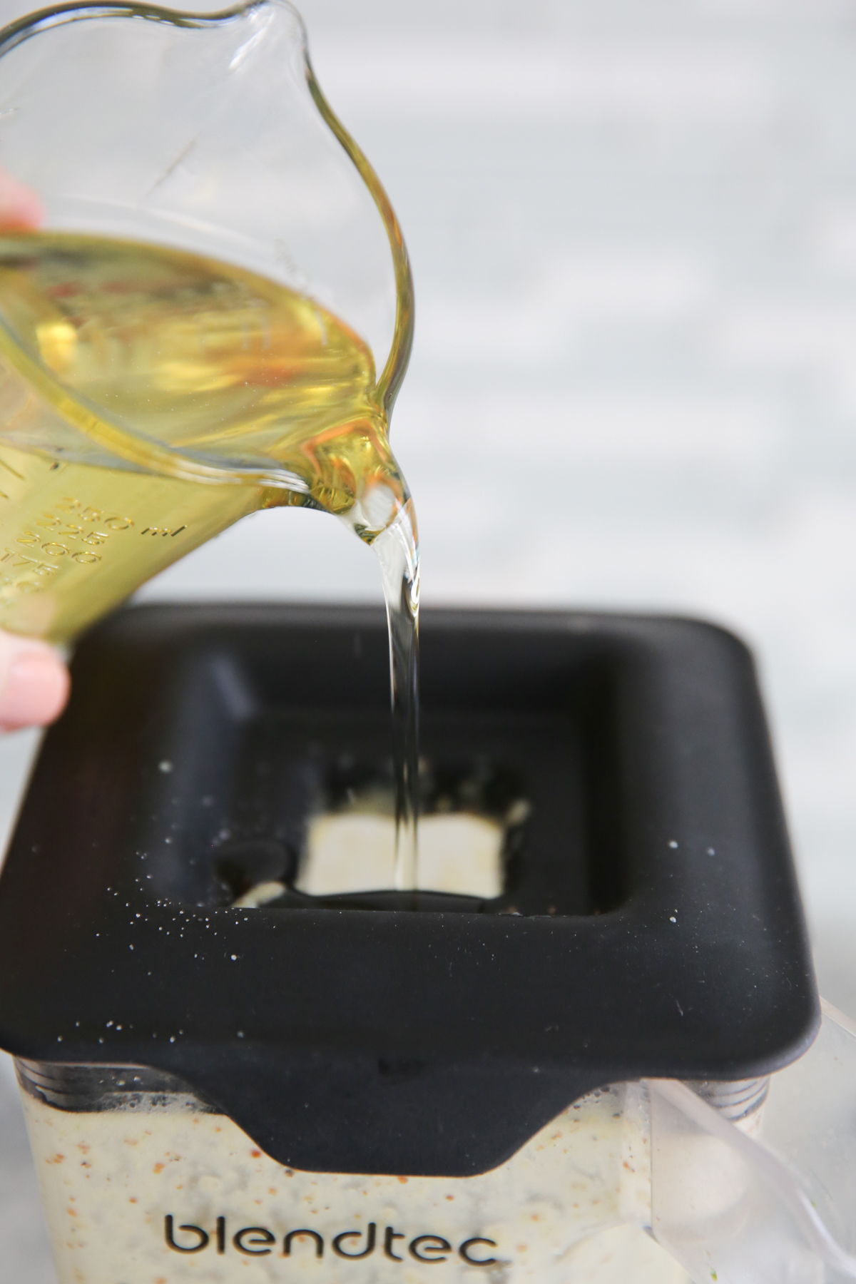 pouring oil into the top of a blender