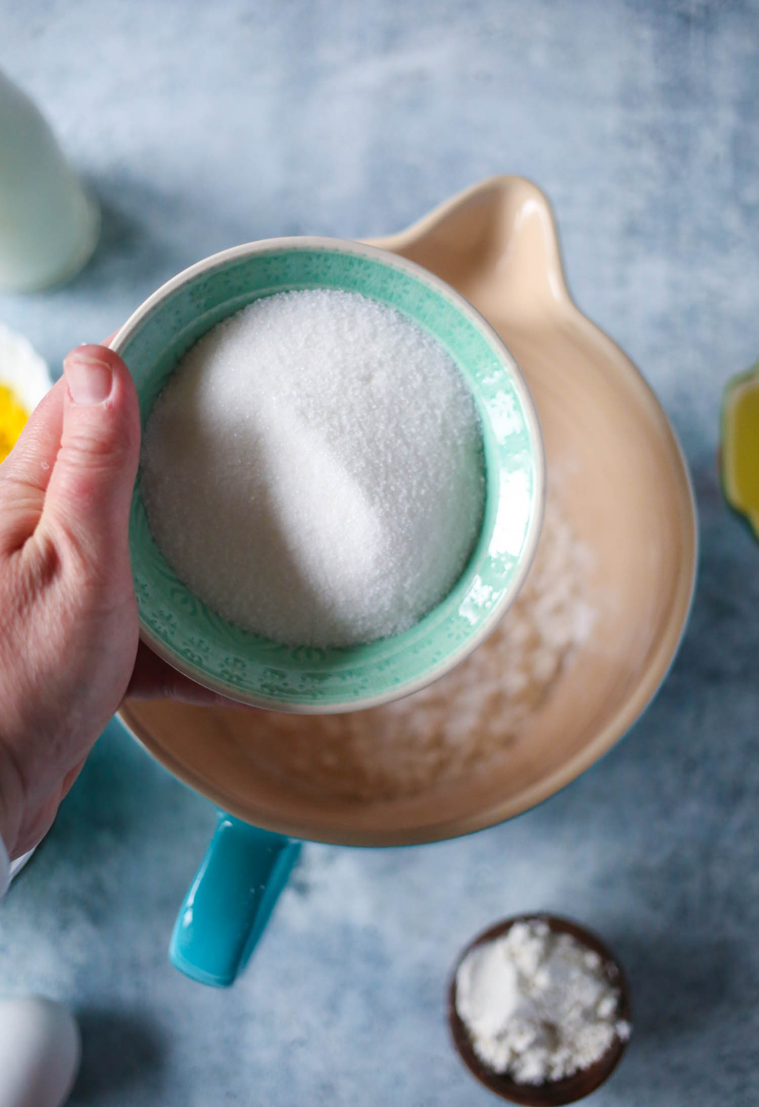 adding sugar to streusel topped blueberry muffins from our best bites