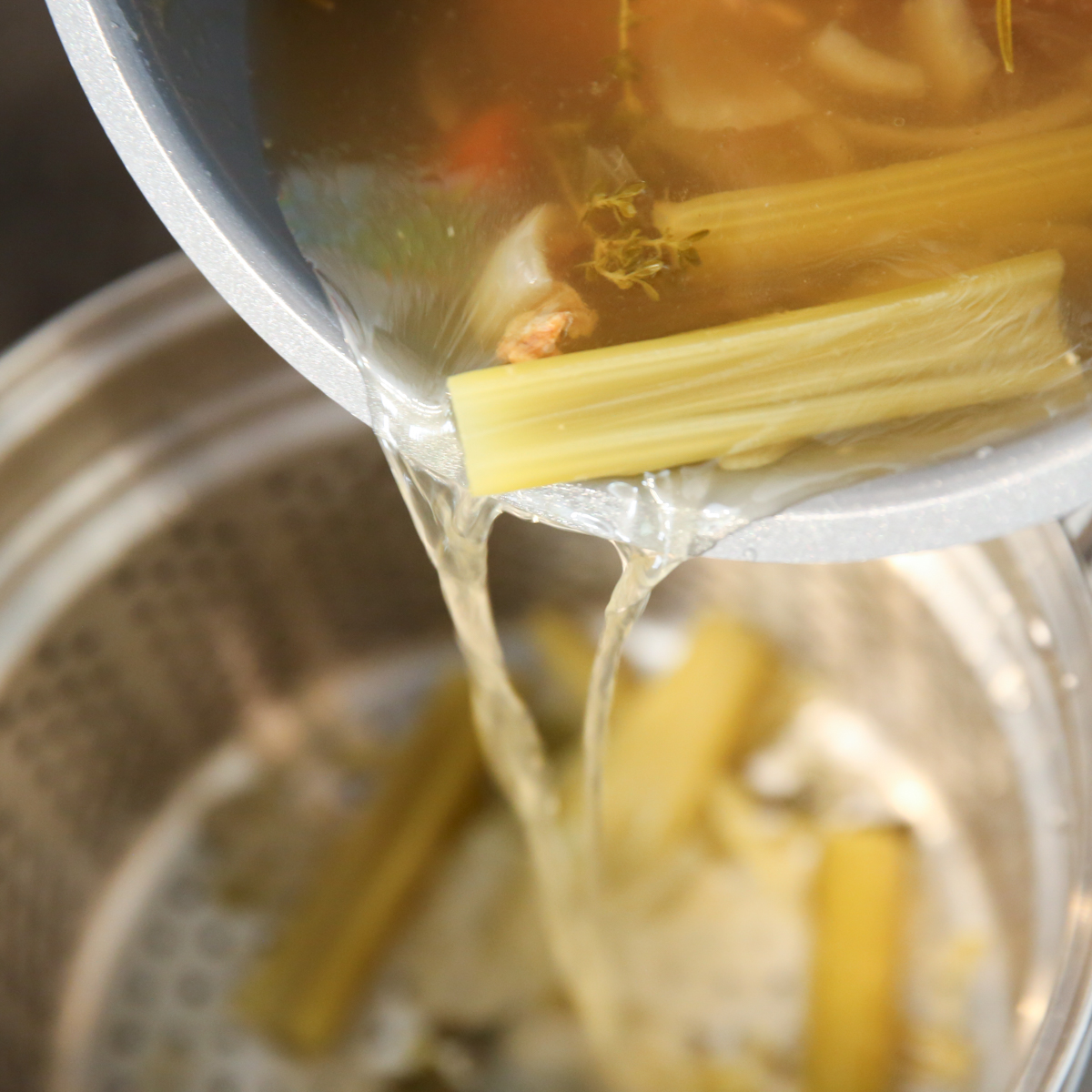 pouring out Homemade Chicken Broth