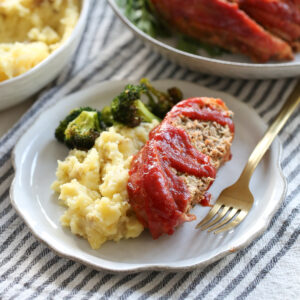 meatloaf on a plate with mashed potatoes and broccoli