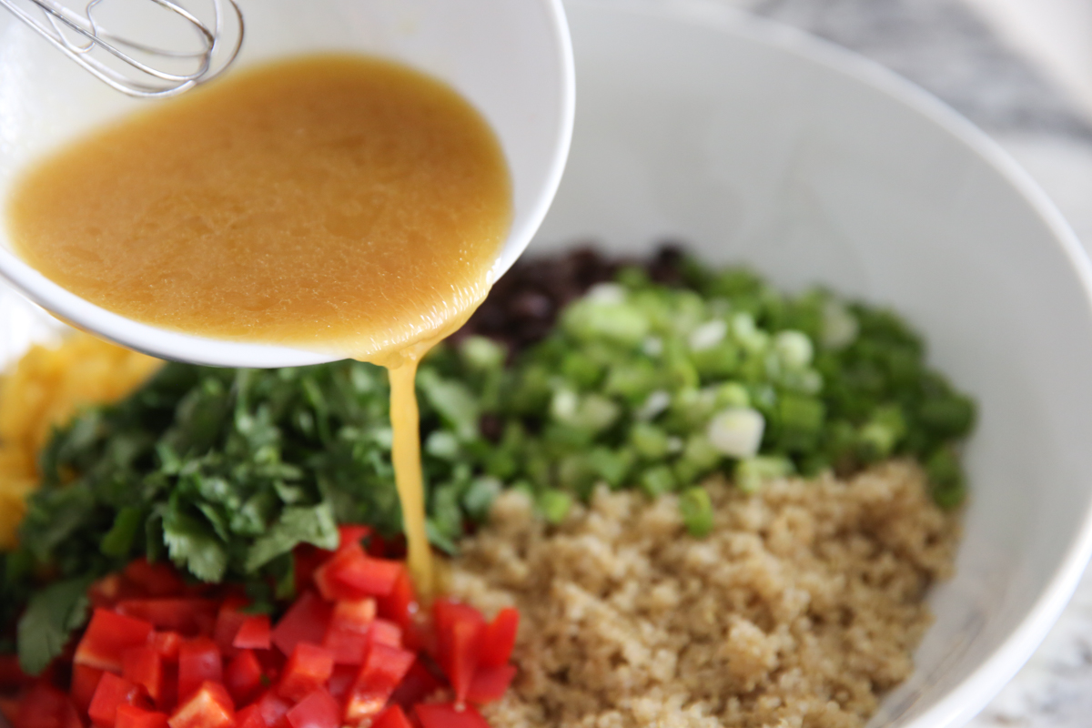 pouring dressing over quinoa salad