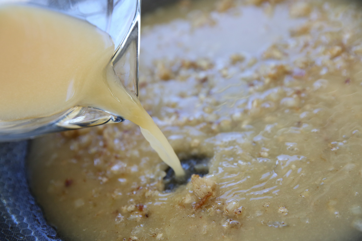pouring broth in a skillet