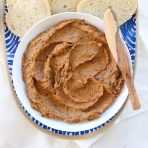 Eggplant spread in a white bowl with a spreader