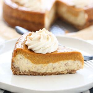 slice of pumpkin pie on top of a cheesecake
