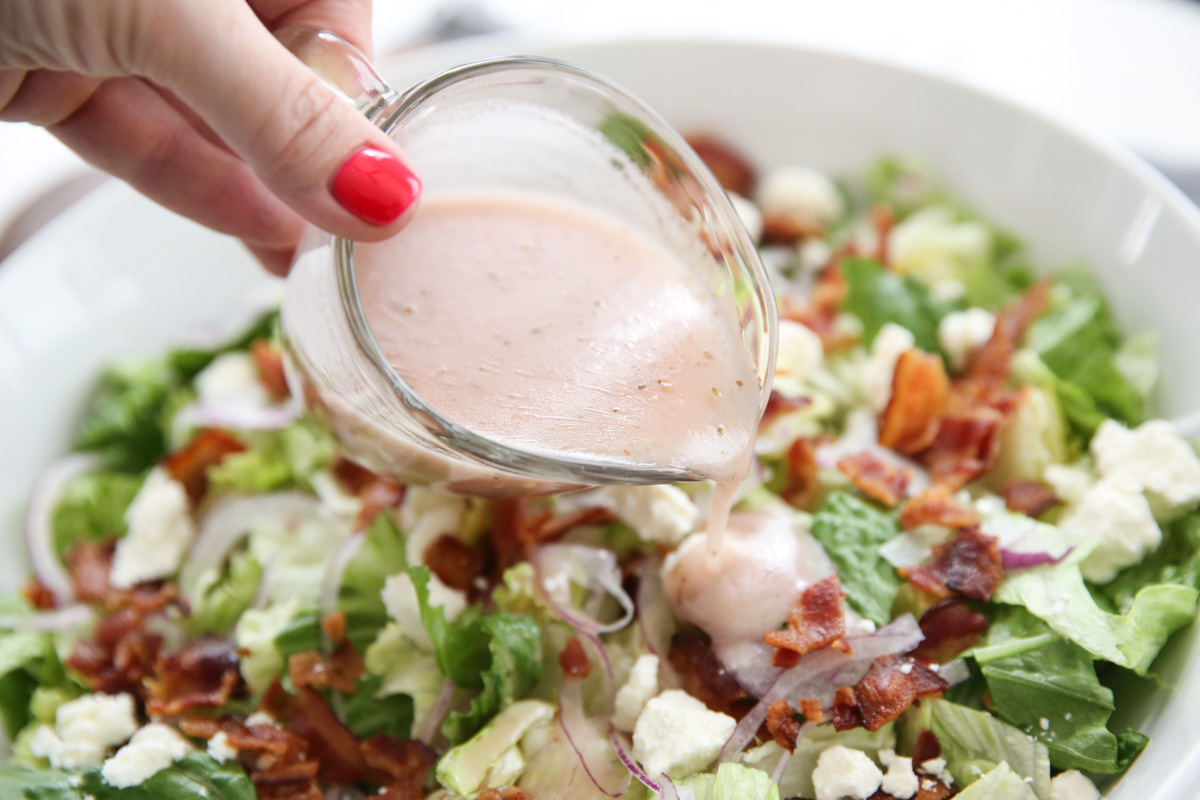 pouring dressing on salad
