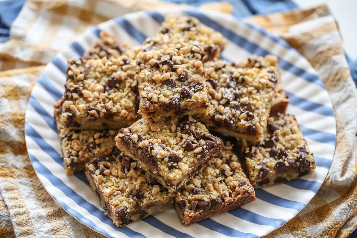 Toffee Chocolate Chip Cookie Bars stacked on a striped plate