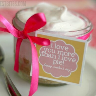 A cute little frozen lemonade pie in a jar with a pink ribbon tied around it and a tag that says "I love you more than I love pie!"