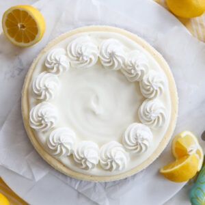 Lemon Cheesecake on a platter with sliced lemons