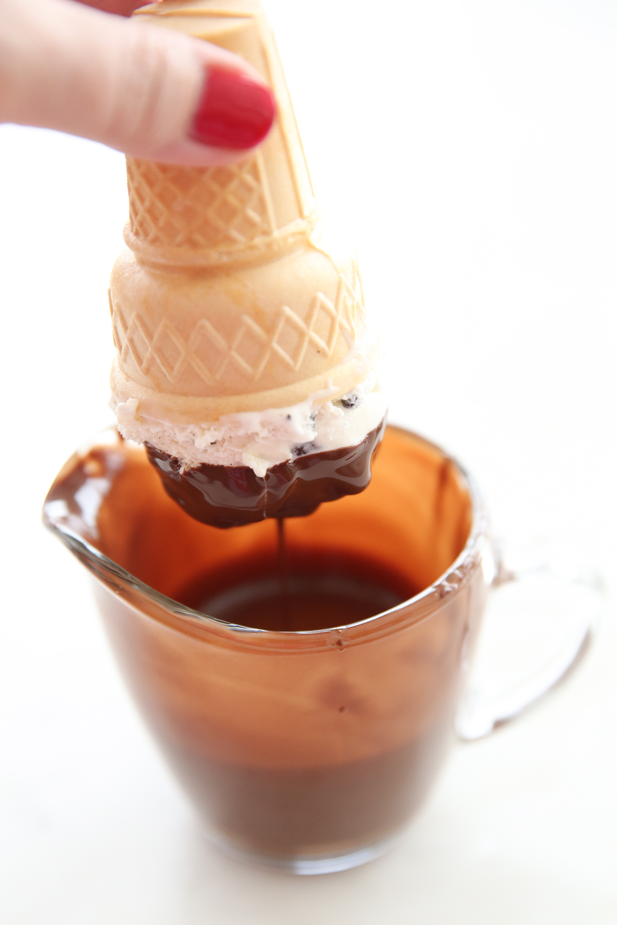 dipping an ice cream cone into melted chocolate