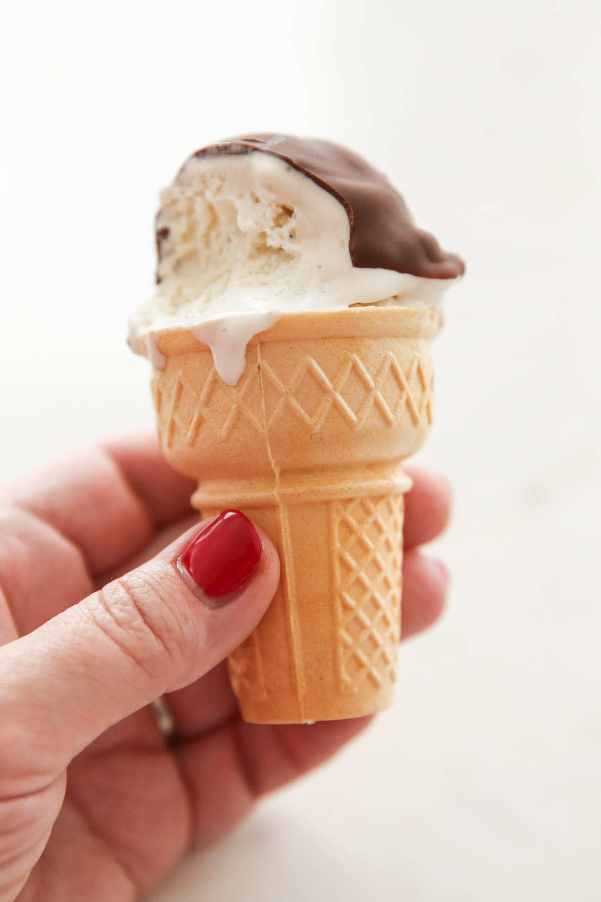 dipping an ice cream cone into melted chocolate