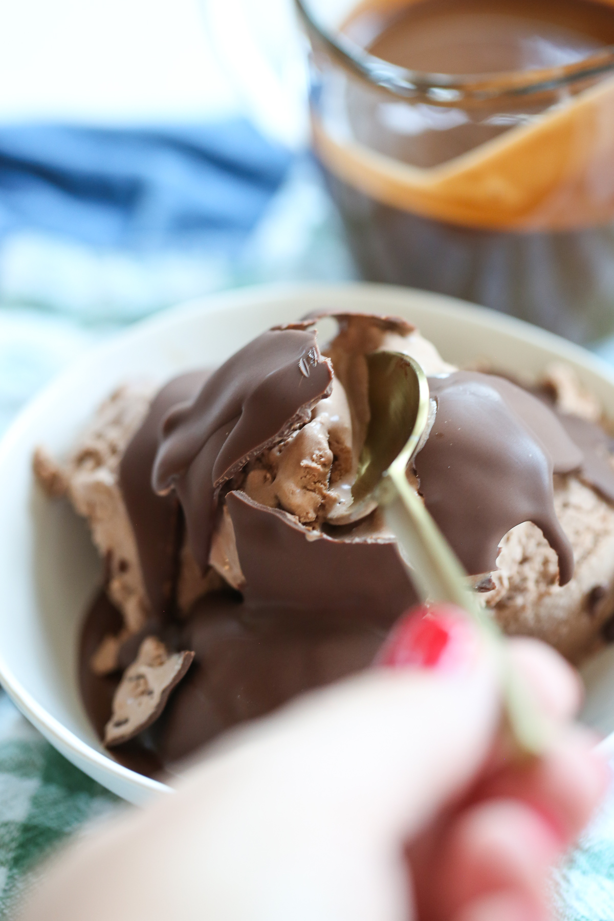 cracking homemade magic shell over ice cream
