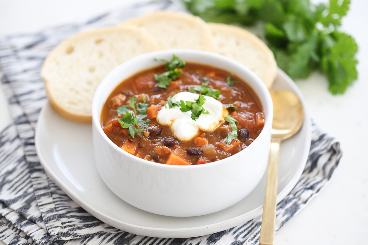 turkey sweet potato chili in a bowl with bread on the side