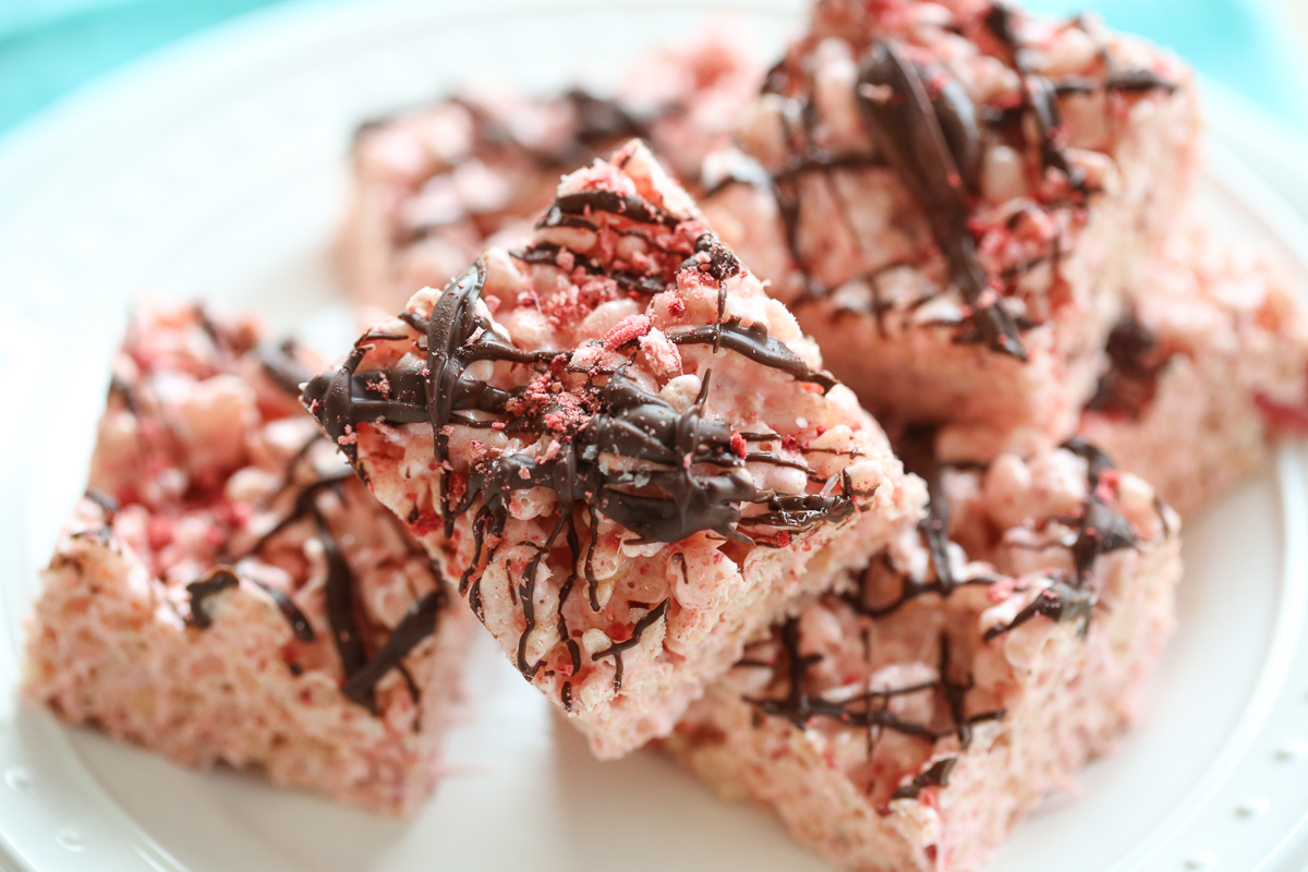 chocolate drizzled strawberry rice krispie treats on a plate