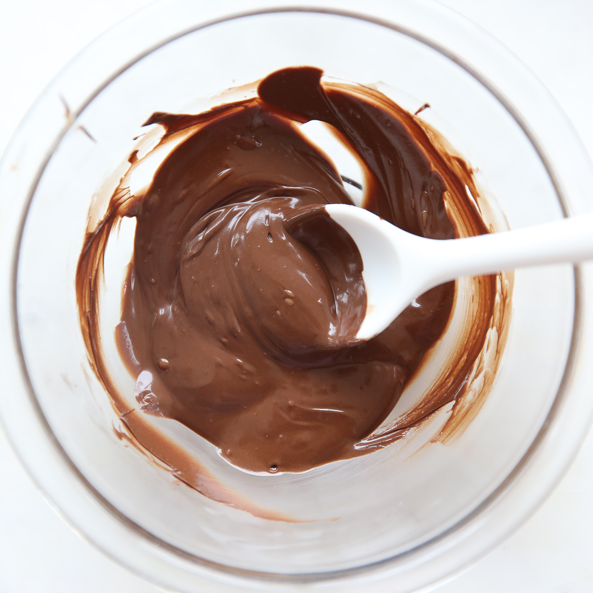 bowl of melted chocolate with a white spoon