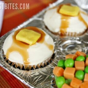 April Fools cupcake decorated with white frosting to look like mashed potatoes with caramel "gravy" and Starburst "butter" on top.