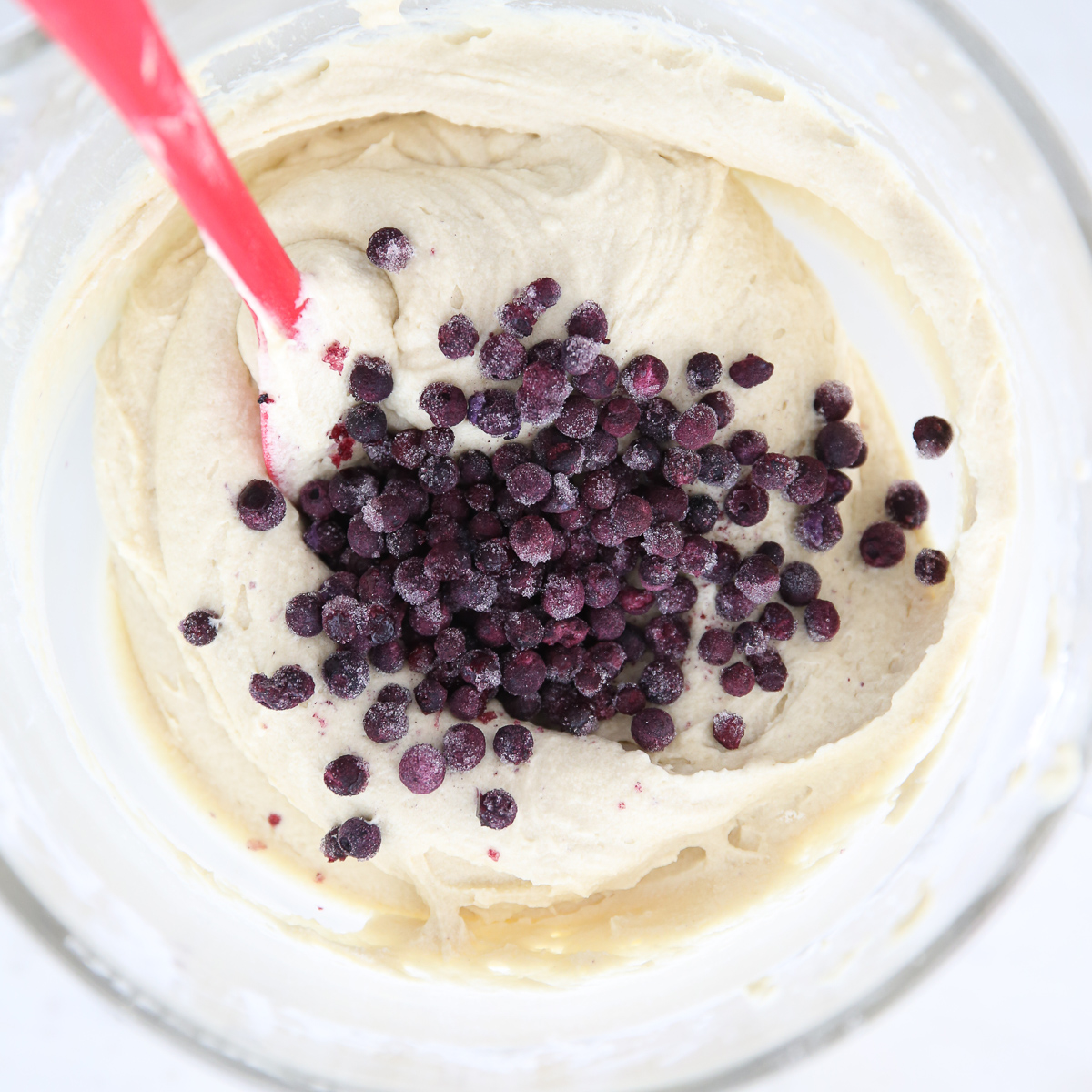 frozen blueberries being mixed into cake batter