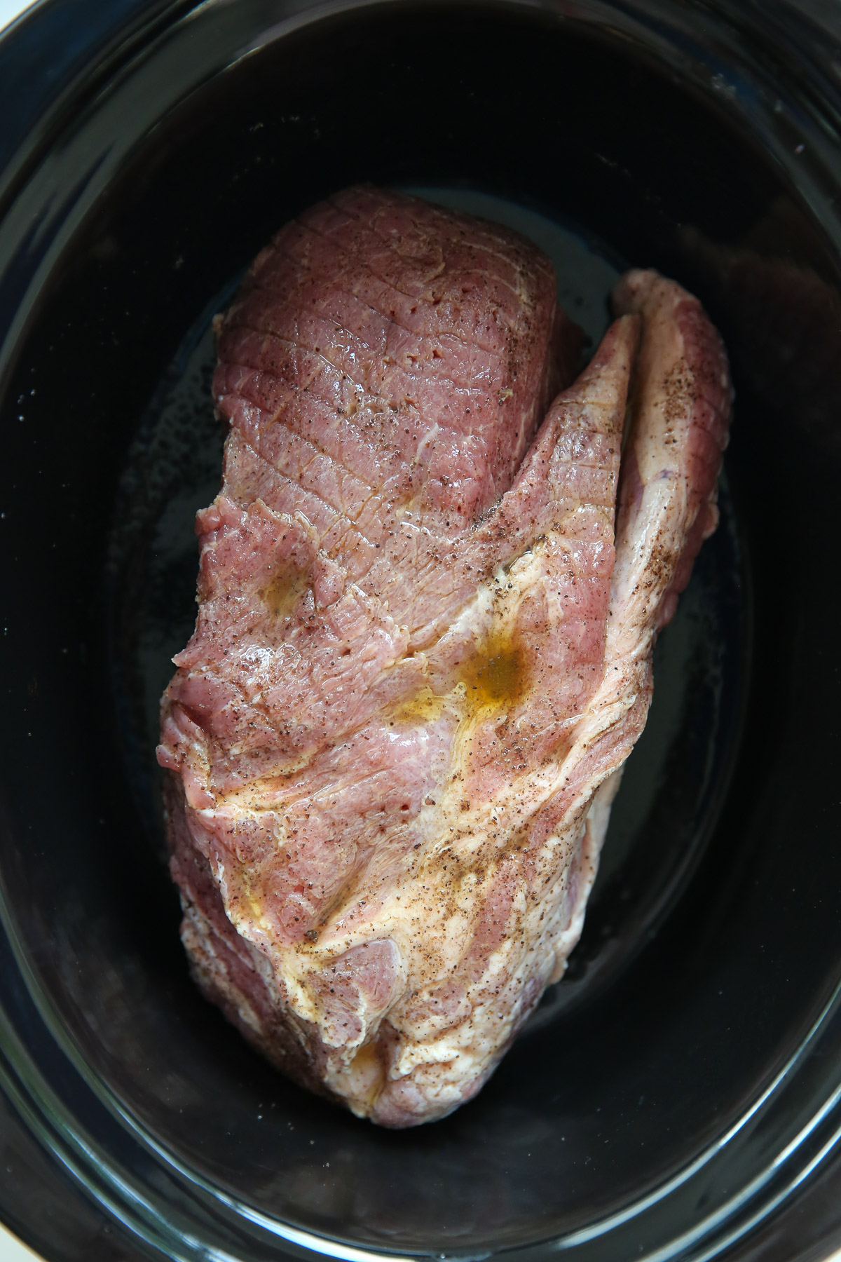 uncooked pork roast in a slow cooker