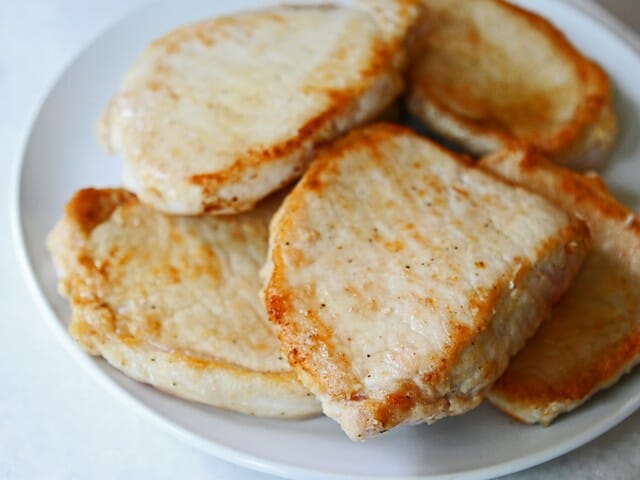 Baked pork chops in creamy Brie and mushroom sauce from Our Best Bites