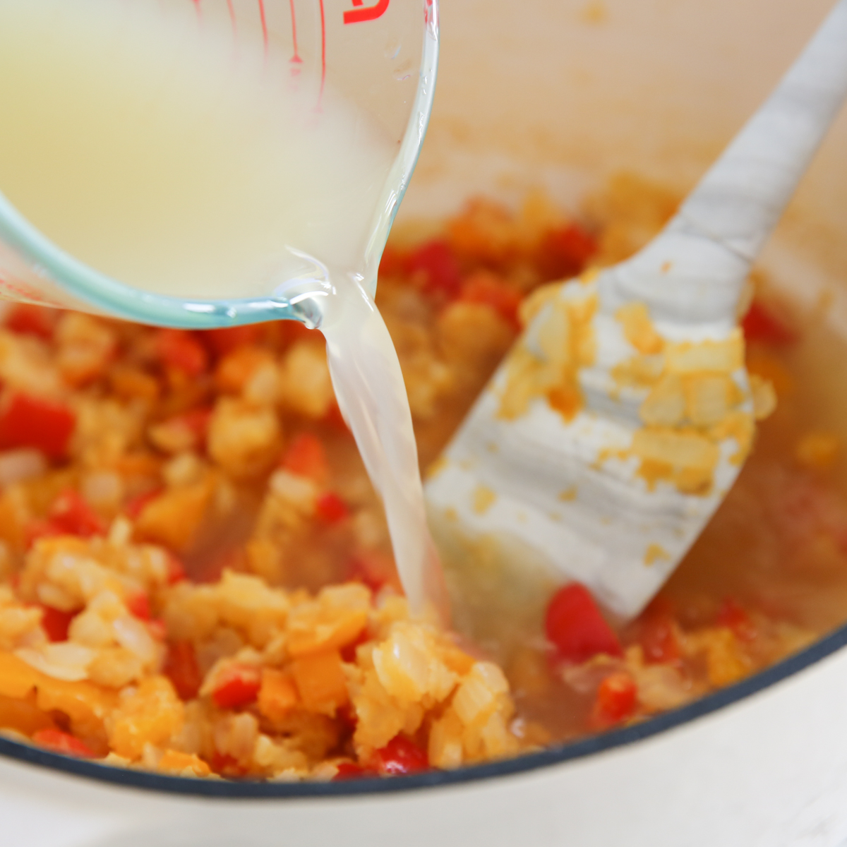pouring broth into soup pot