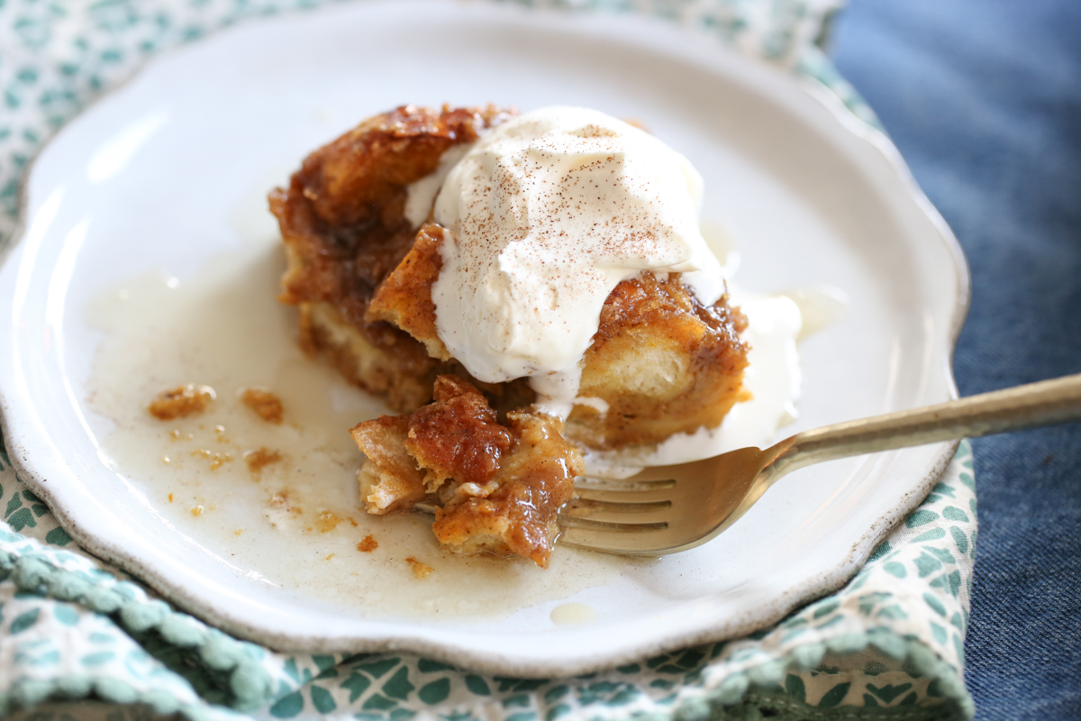 baked square of pumpkin french toast sliced on a plate with whipped cream on top