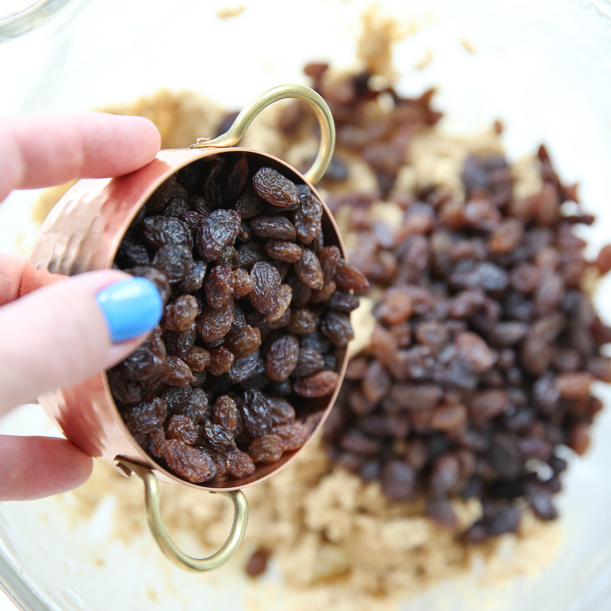 pouring raisins into cookie dough