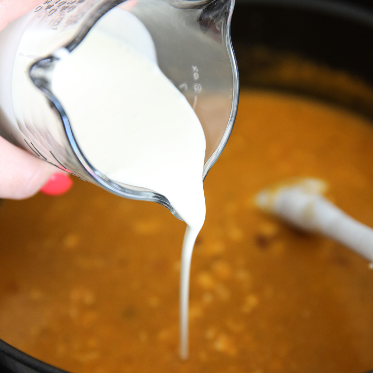 cream being poured into soup