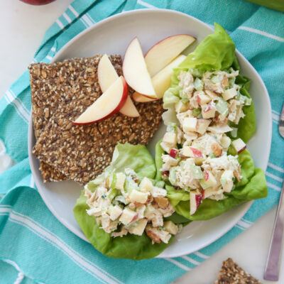 chicken salad on a plate with crackers and apples