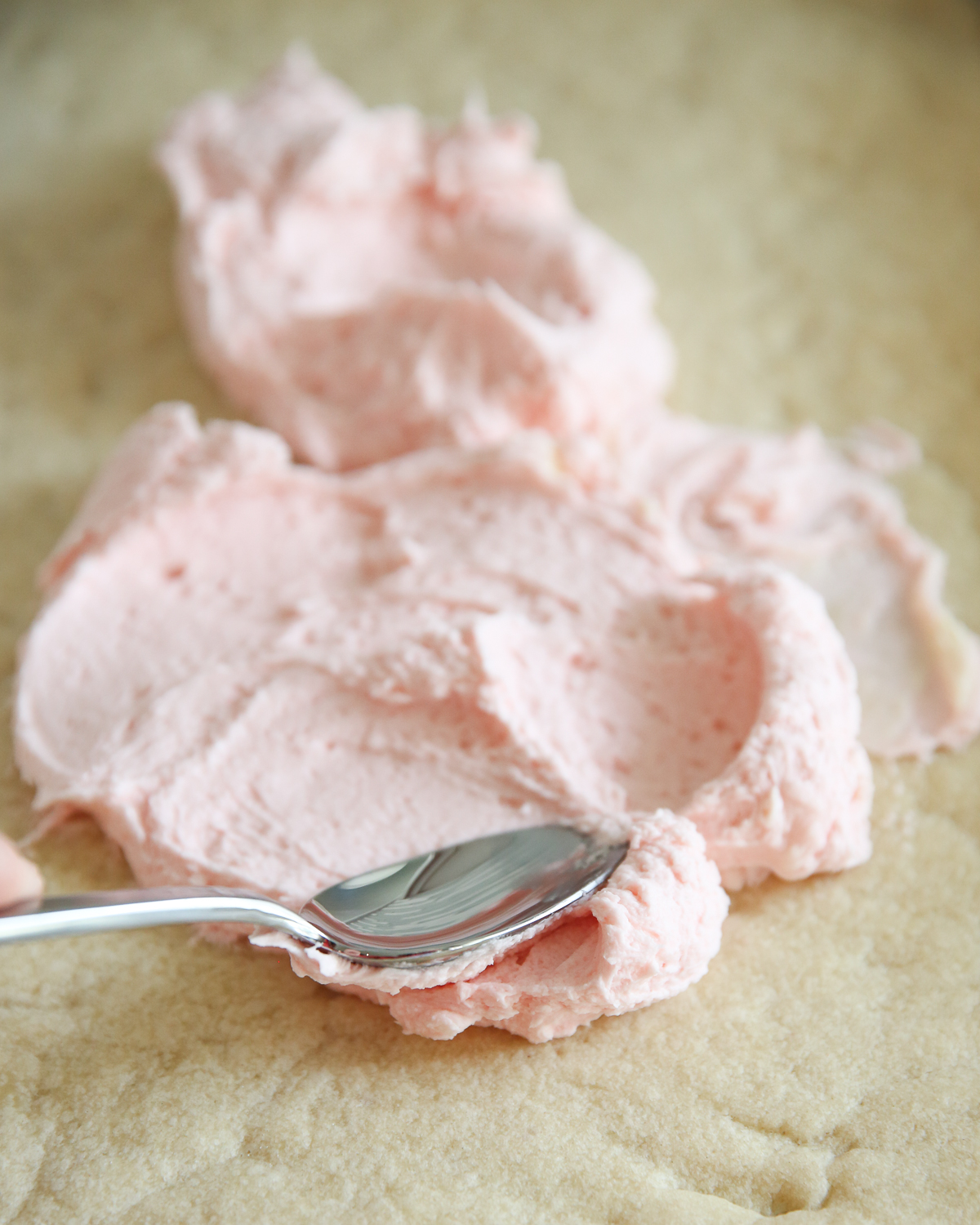 swirled pink frosting on sugar cookies