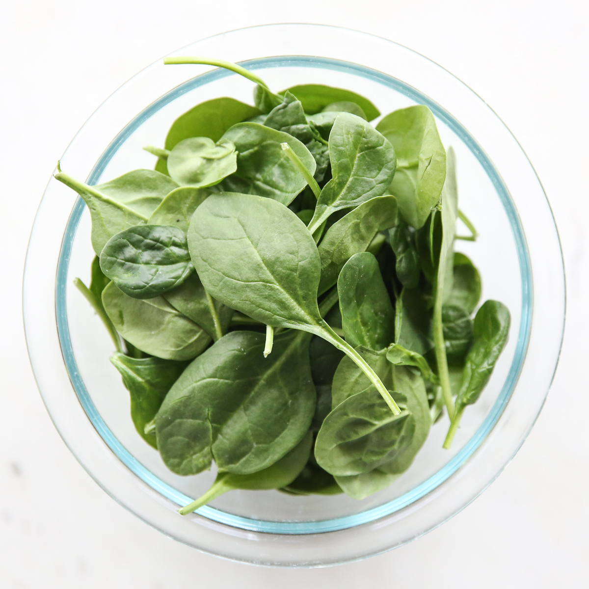 raw spinach in a glass bowl