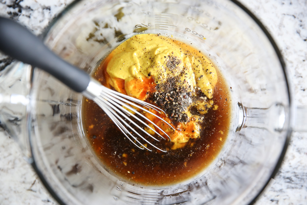 whisking bbq sauce ingredients together in a glass bowl