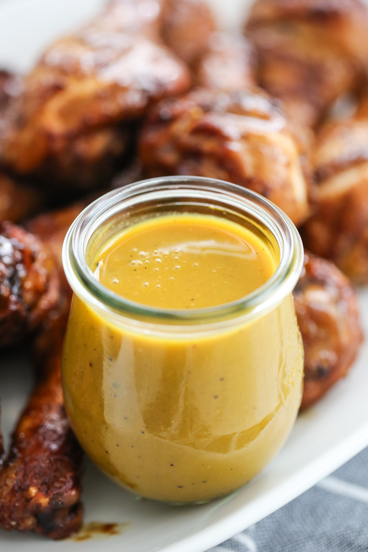 yellow carolina sauce in a jar with grilled chicken