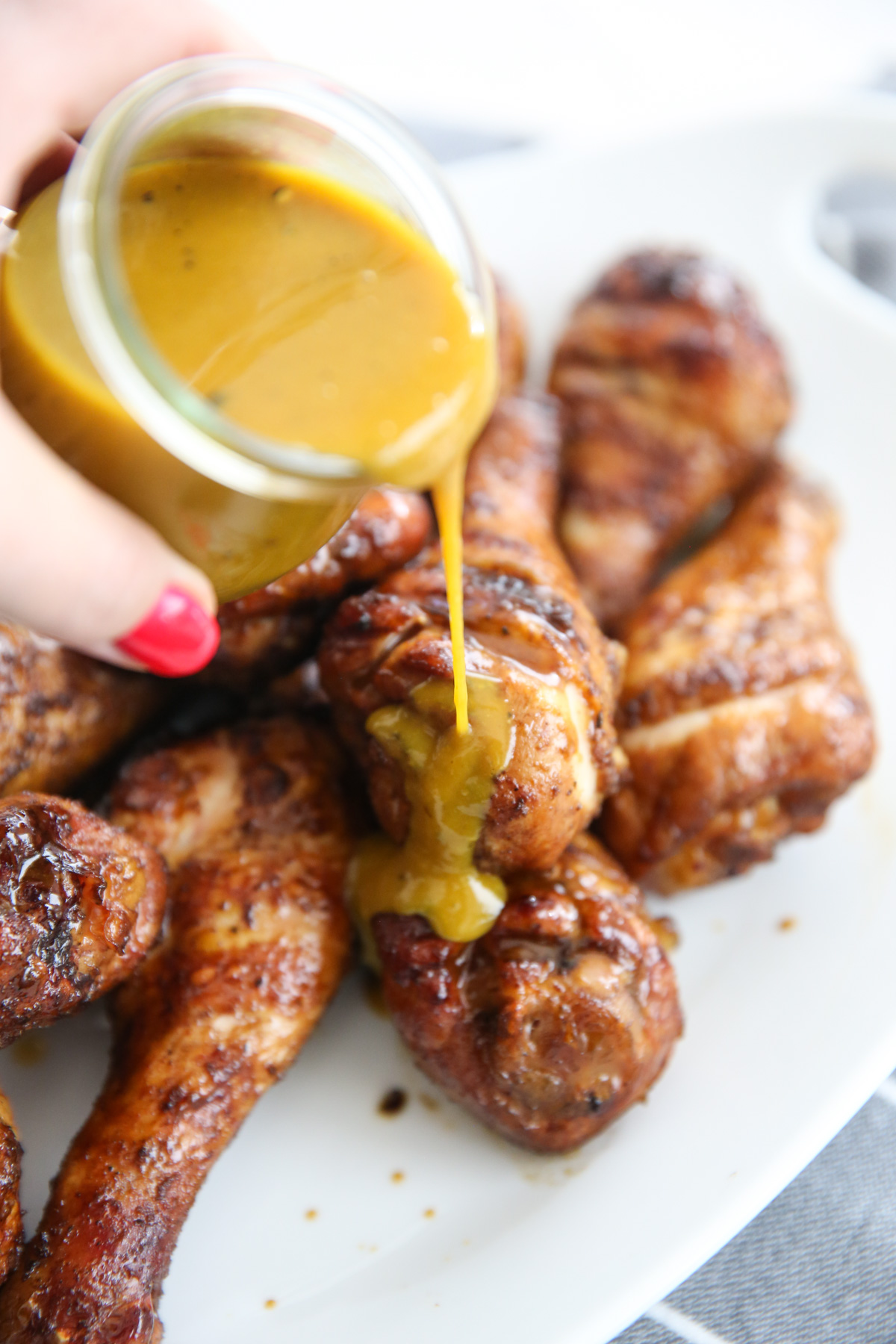 yellow carolina sauce being poured on grilled chicken