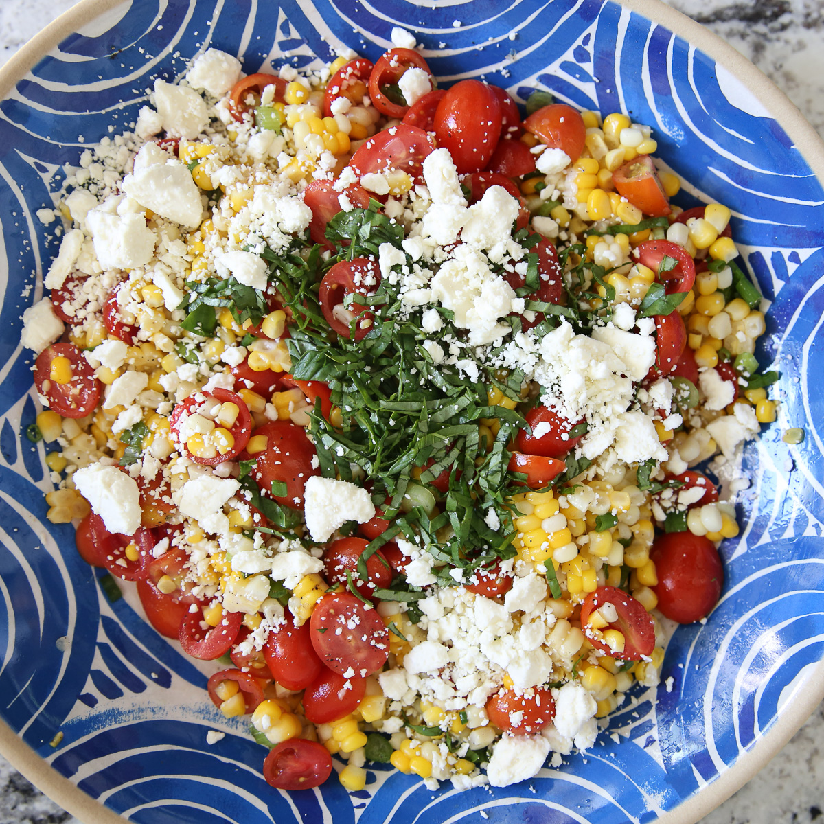 Fresh corn salad in a blue bowl