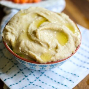 A bowl of hummus, drizzled with olive oil